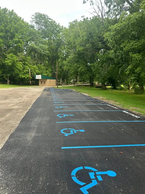 Newly paved and striped accessible parking lane under shade trees