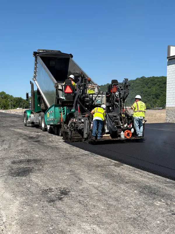 West Virginia Paving crew operating an asphalt paver on a commercial lot